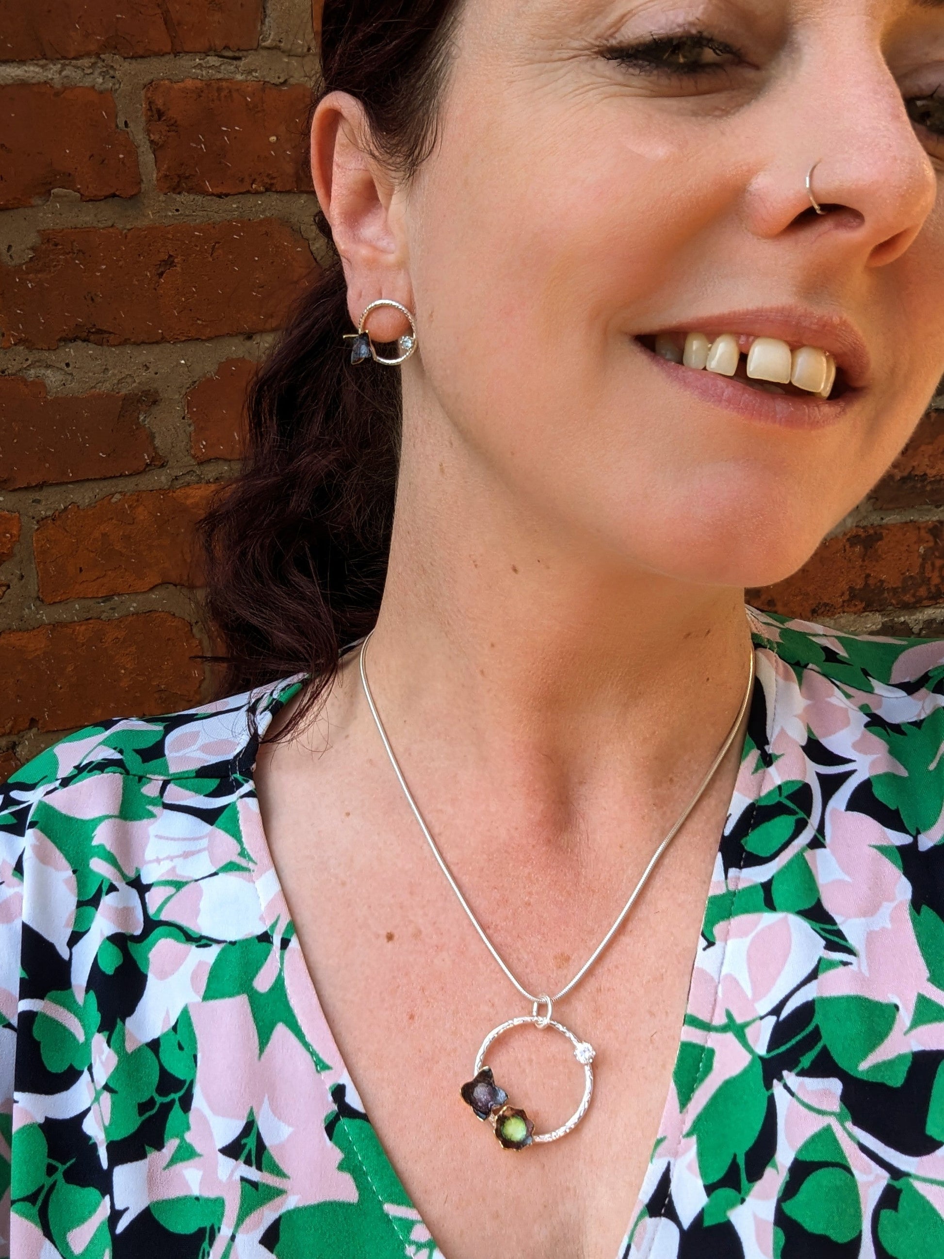 Model wearing floral stud earrings and floral necklace. adorned with cubic zirconia