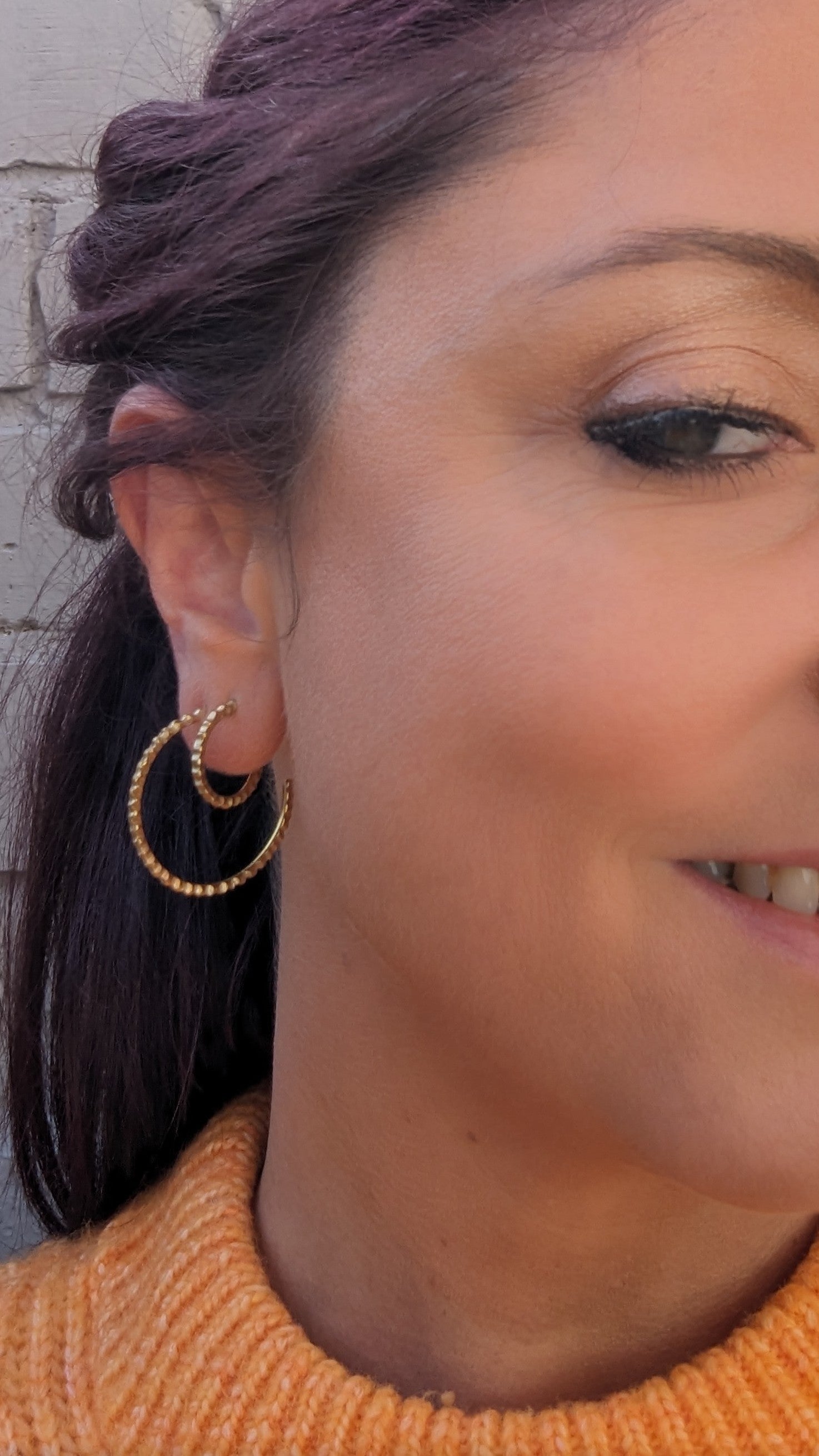 Model adorning goddess hoop earrings.