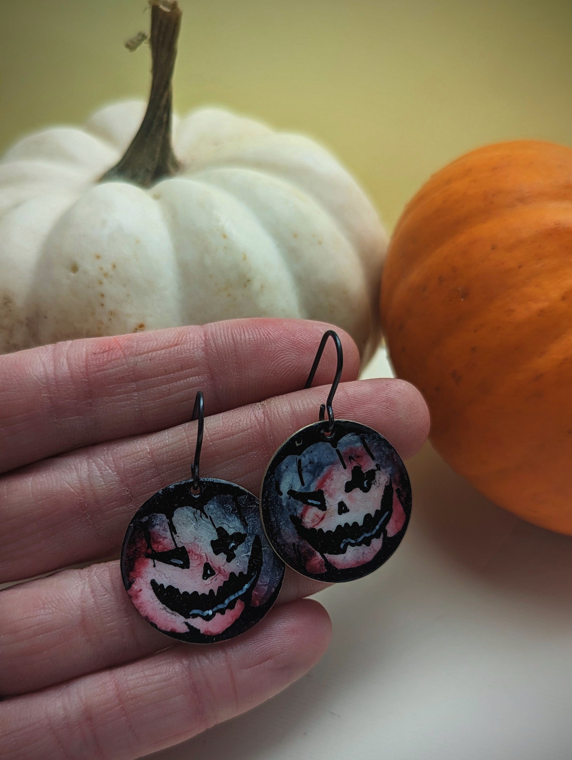 Pumpkin Earrings on display next to pumpkins. Halloween Jewellery