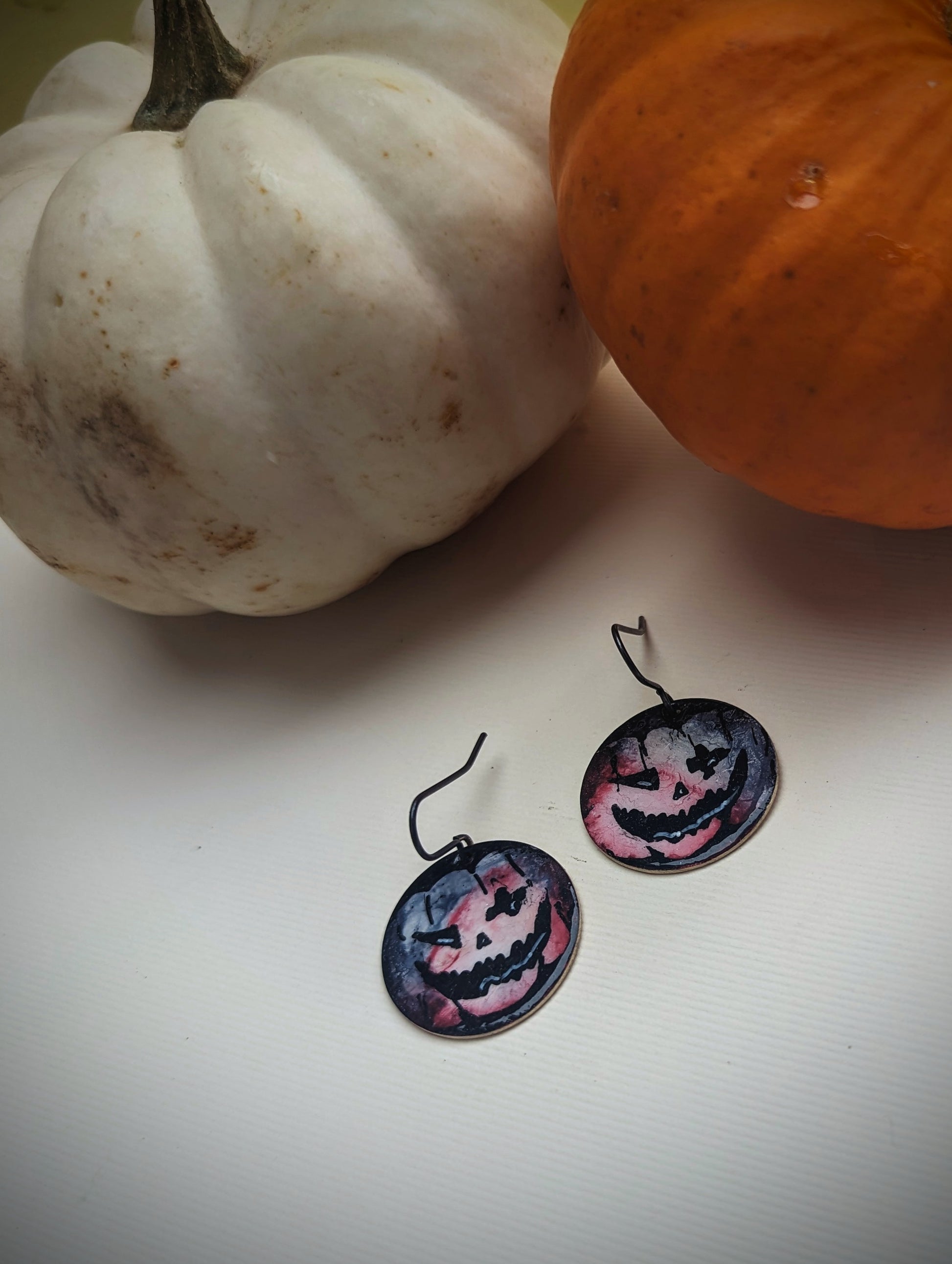 Pumpkin Earrings on display next to pumpkins. Halloween Jewellery