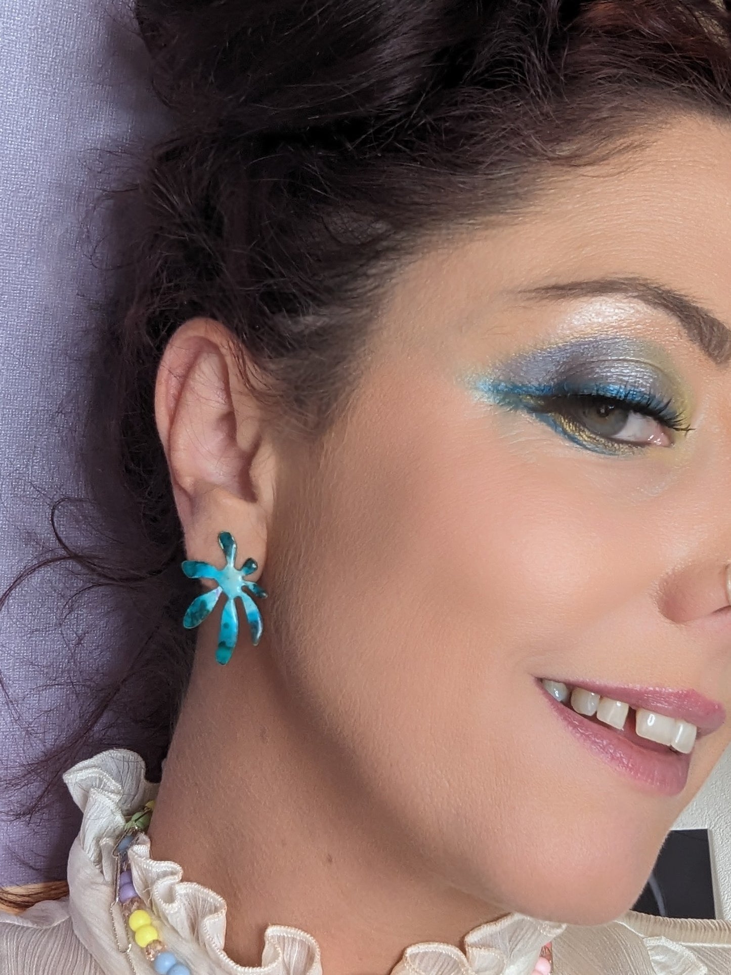 Model wearing blue flower earrings