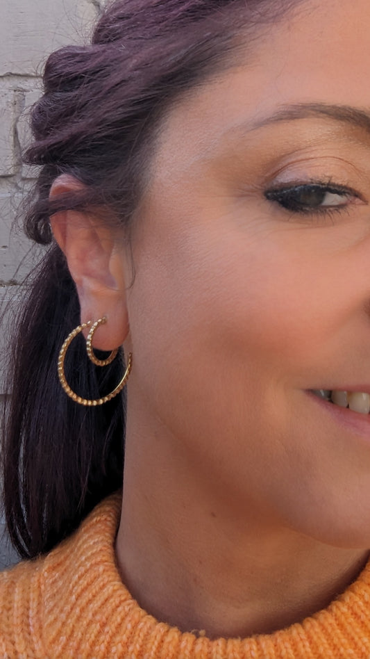 Model adorning goddess hoop earrings. 