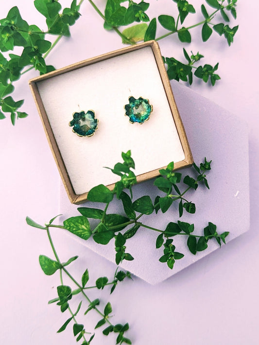 Green stud earrings displayed in Jewellery box