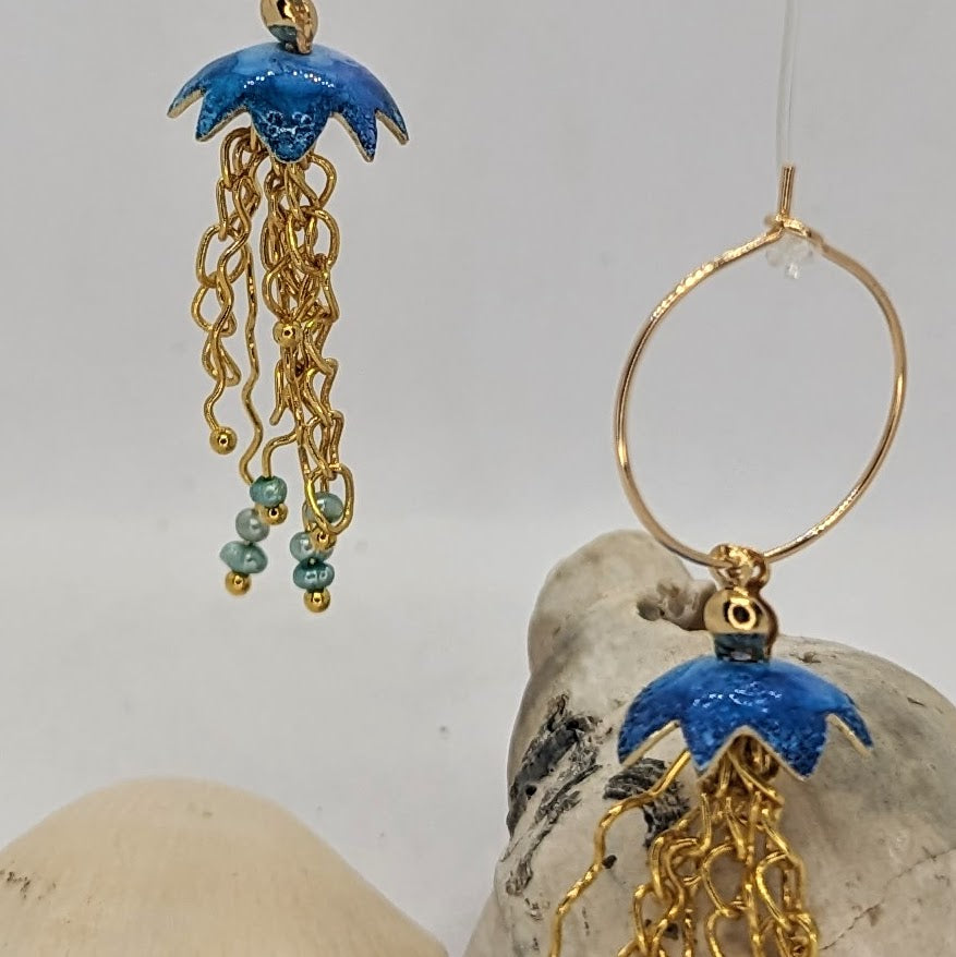 Blue Jelly fish inspired earrings with a cascade of gold plated tentacles with freshwater pearls. Displayed with sea shells 